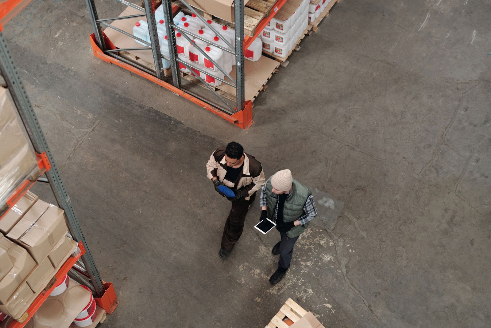 Two people reviewing information together on a warehouse floor