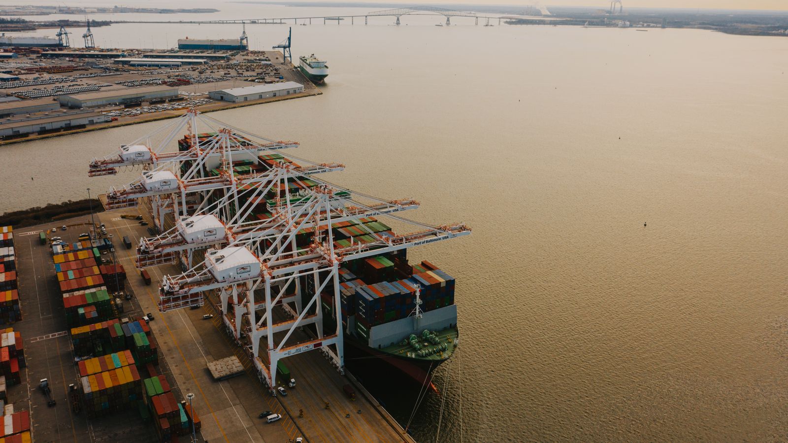 Port cranes, cargo ships and container yards beside the water