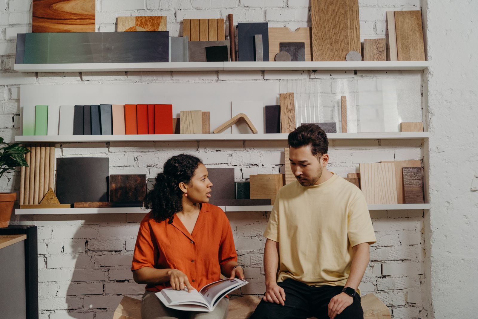 Two people discussing a product catalog in a materials showroom