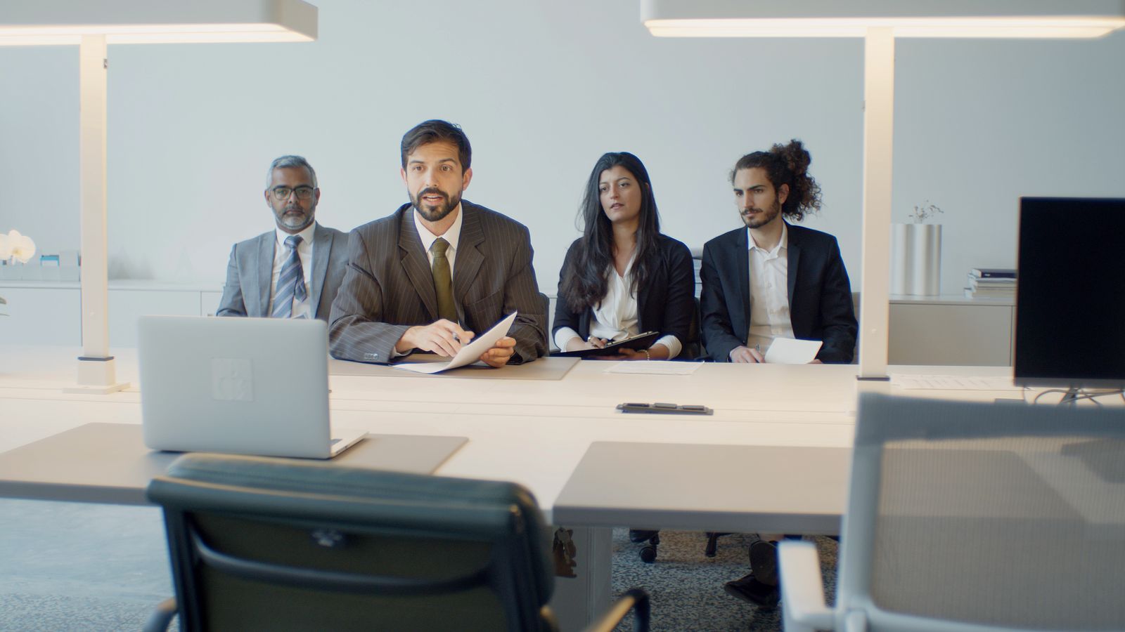 Participants facing a conference screen during a remote meeting