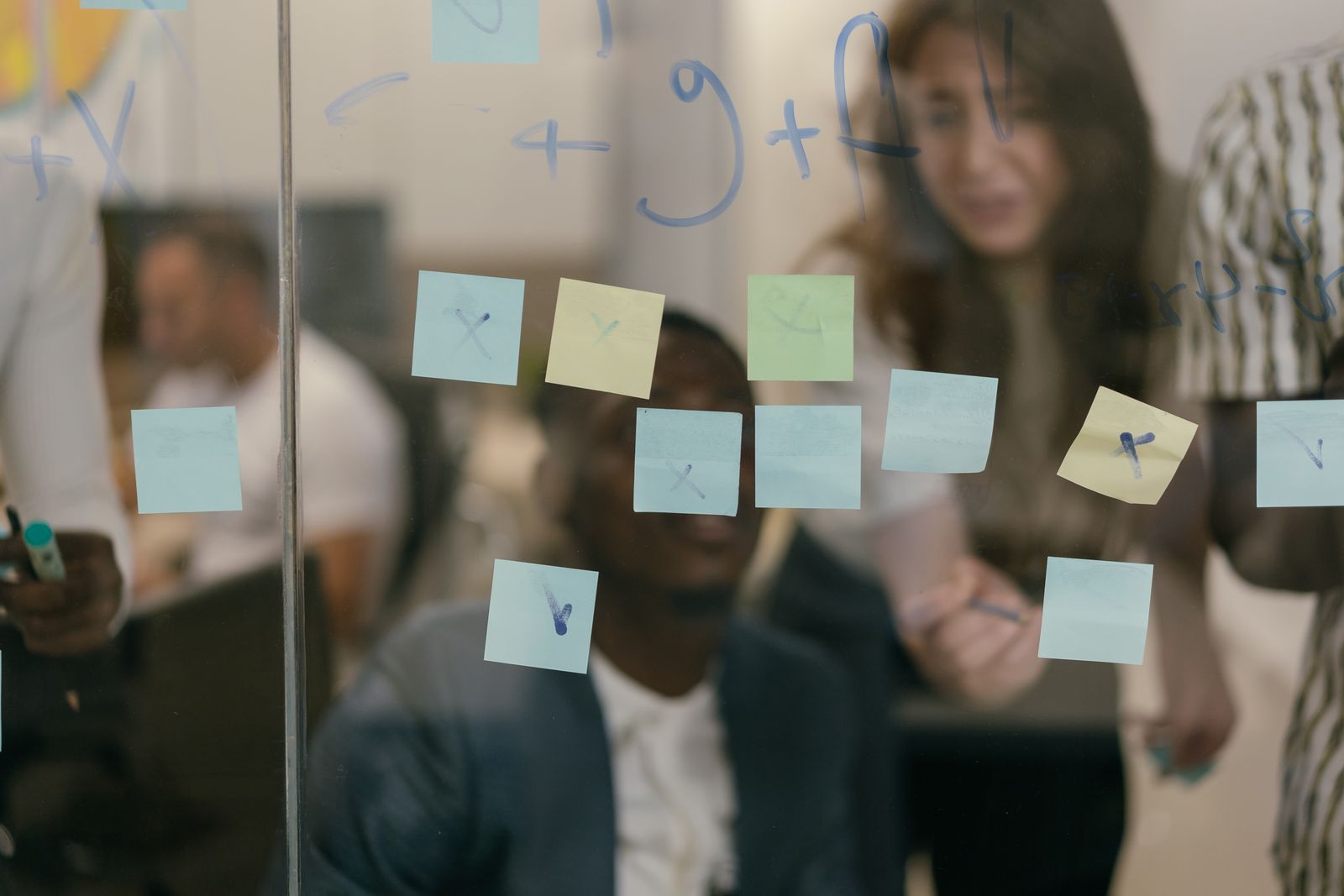 Colleagues mapping ideas together on a glass work board